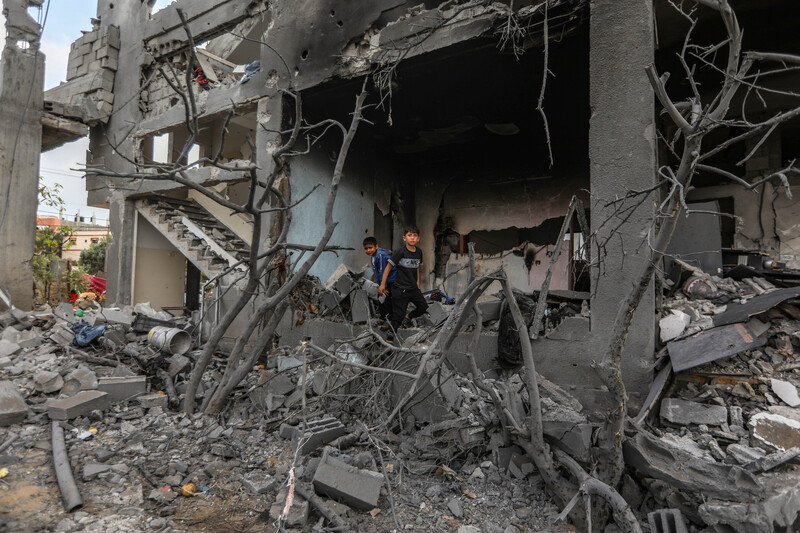 Children stand in the rubble of a bombed building 