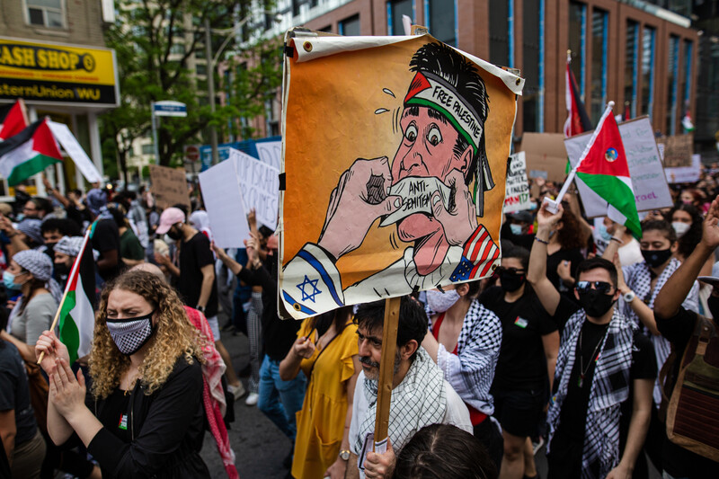 A group of protesters hold signs