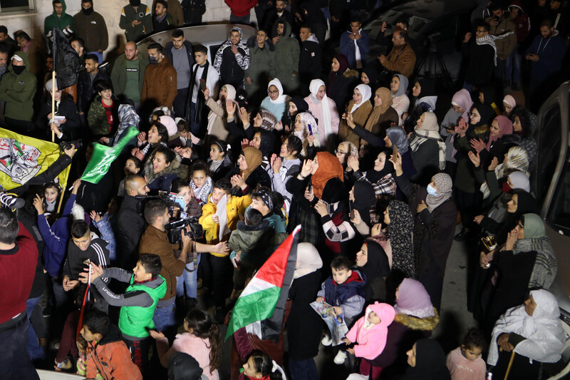 People celebrate with flags in the street