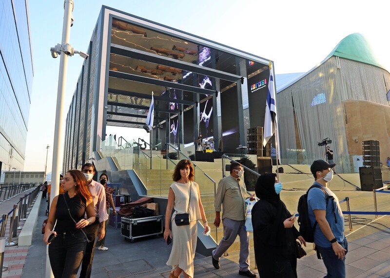 People walk around an exhibition structure 