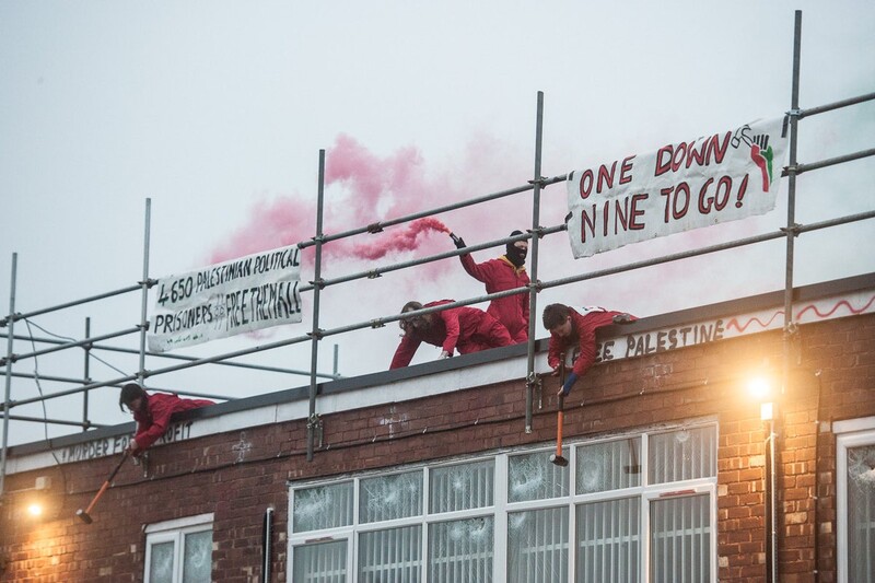 Activists on a rooftop smash windows