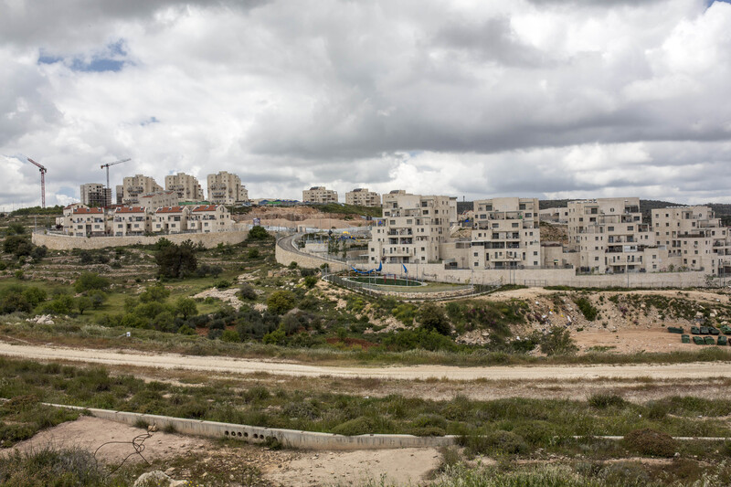 Apartment buildings and cranes against cloudy sky