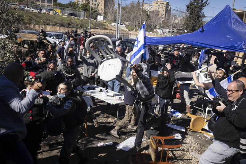 Men throw chairs in a crowd