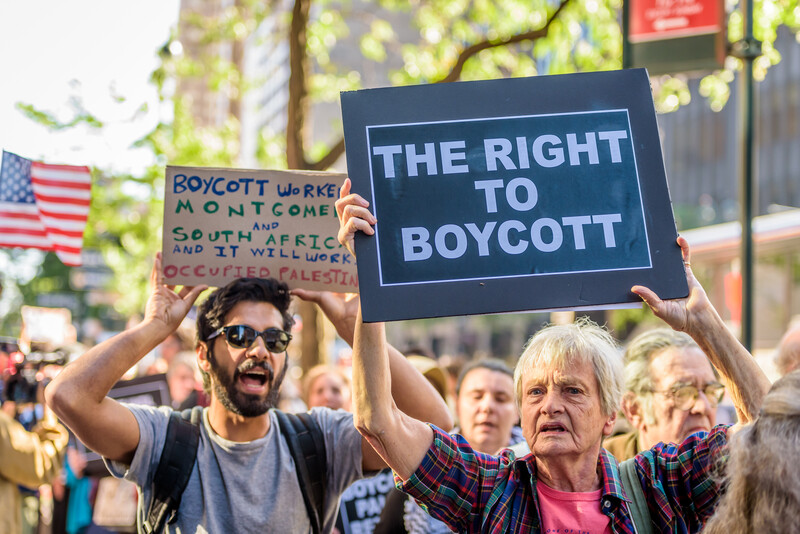 Protesters hold signs