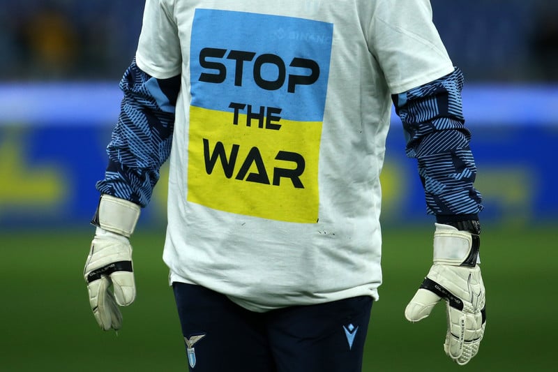 Man's torso wearing a shirt with the Ukrainian flag that reads "stop the war"
