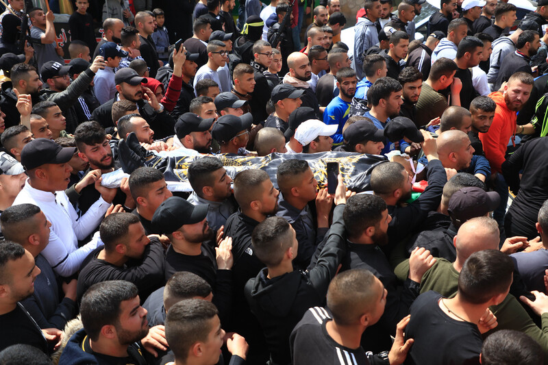 People carry the body of a boy on a stretcher 
