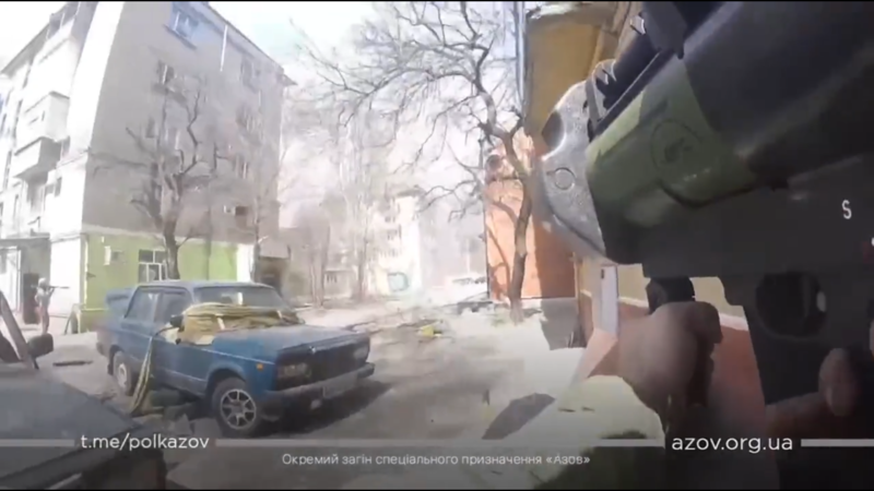 Video still from the point of view of a man holding an anti-tank weapon