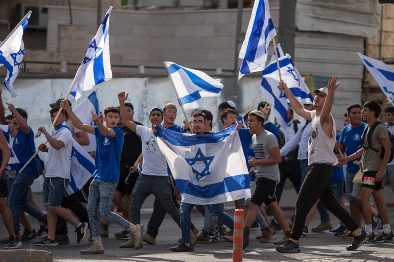 Crowd of Israeli flag-carriers marches, some raise their middle fingers 
