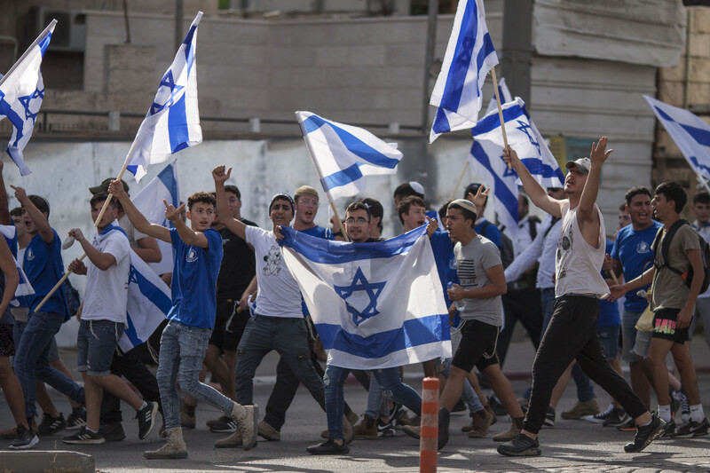 Crowd of Israeli flag-carriers marches, some raise their middle fingers 