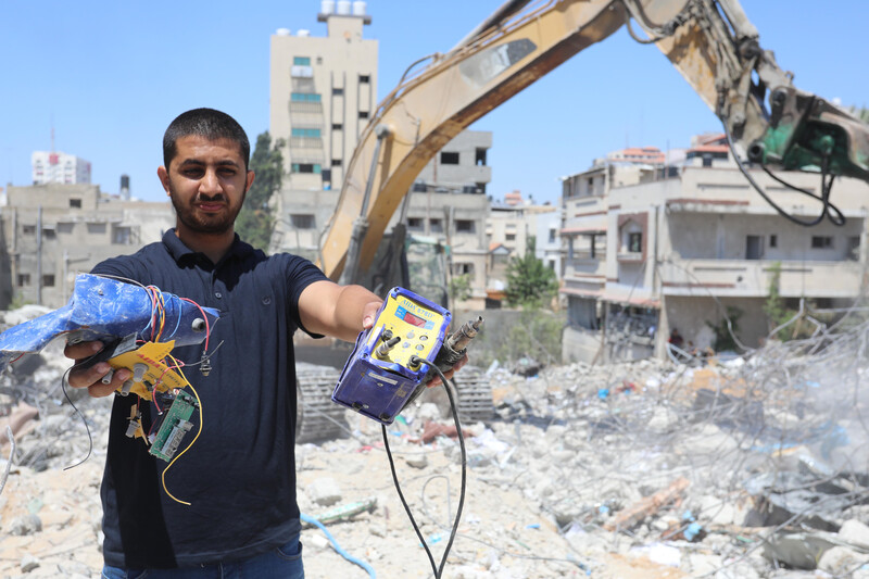 A man shows off what he has found in the rubble of a building