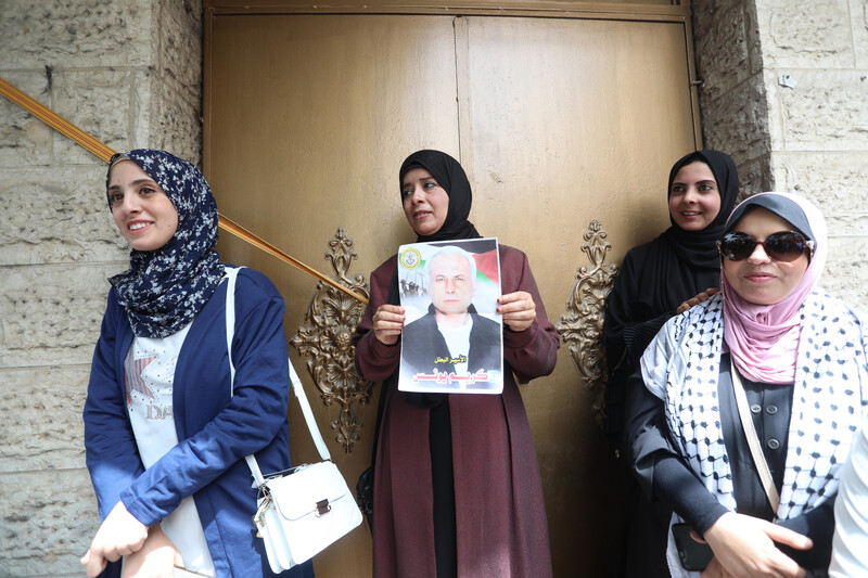 A woman holds up a picture of an imprisoned relative at a protest in Gaza