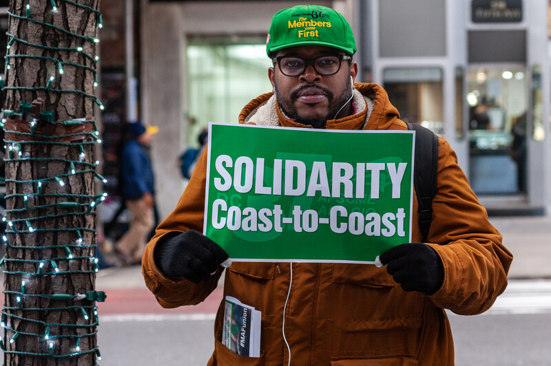 A man holds a sign