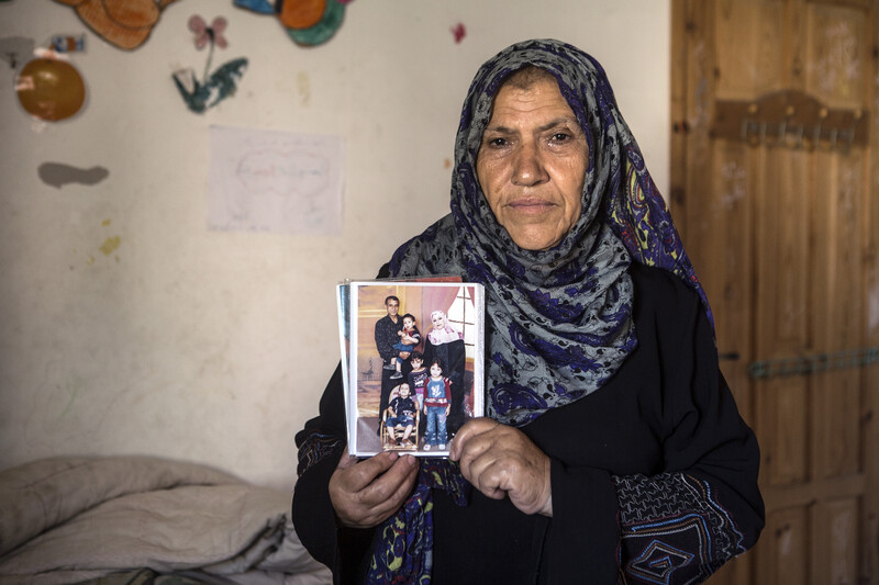 A woman holds a photograph in front of her