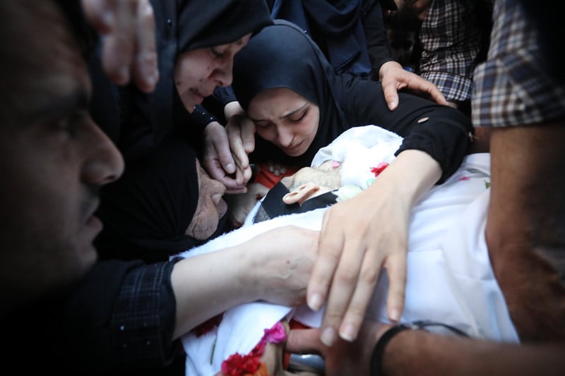 Palestinians mourn over the body of Islamic Jihad commander Yasir al-Masri, who died from injuries sustained during an Israeli airstrike on Gaza in May 2021, in Deir al-Balah, central Gaza Strip, 2 June. (Ashraf Amra/ APA images)