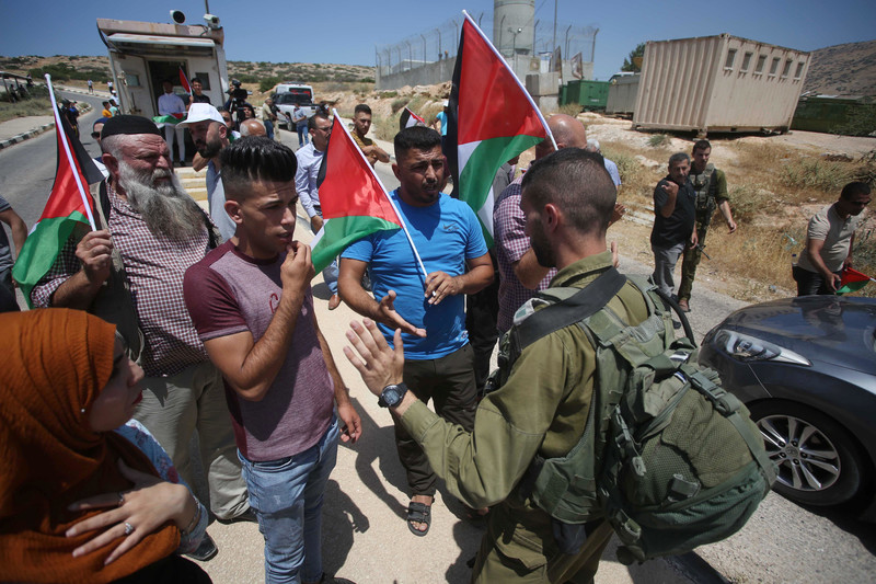 Israeli soldiers argue with Palestinian demonstrators during a protest at Tayasir checkpoint near Tubas against settlements in the Jordan Valley, 6 June.  (Shadi Jarar’ah/ APA images)