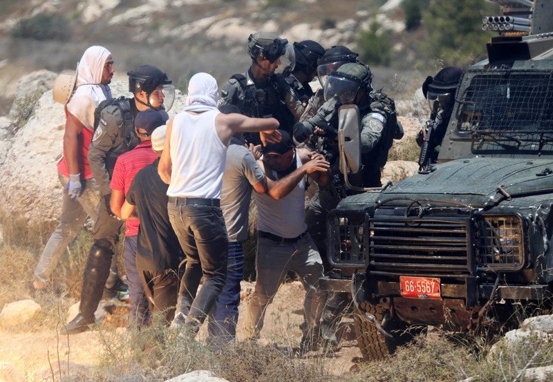 Palestinians scuffle with Israeli forces during a protest against settlements in the West Bank city of Hebron on 11 June. (Mamoun Wazwaz/ APA images)