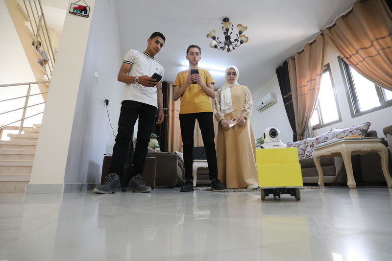 Teenagers in Rafah, southern Gaza Strip, demonstrate a smart rescue robot that they invented to help locate people trapped under the rubble of collapsed buildings, 16 June. The miniature car-shaped device, equipped with Wi-Fi remote control function, was developed by Rama Ibrahim, her brother Ahmed and their classmate Yousef Aqil, all of whom are secondary school students, following months of research and experiment.  (Ashraf Amra/ APA images)