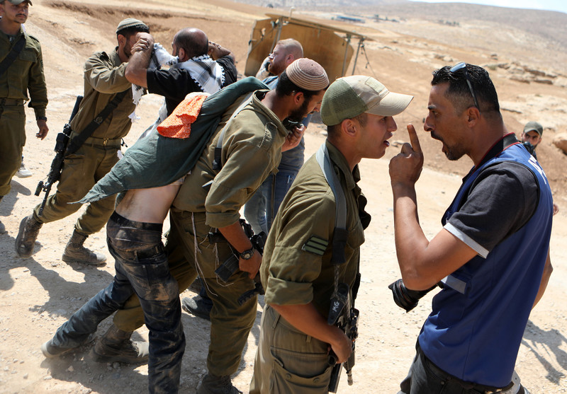 Israeli soldiers confront Palestinian activists during a protest in Masafer Yatta, south of the West Bank city of Hebron, on 22 June.  (Mamoun Wazwaz/ APA images)