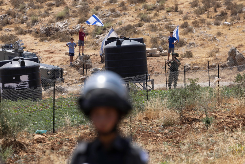 Israeli occupation forces protect Jewish settlers who invaded a water spring on Palestinian land in the West Bank village of Qaryut on 24 June.  (Oren Ziv/ ActiveStills)