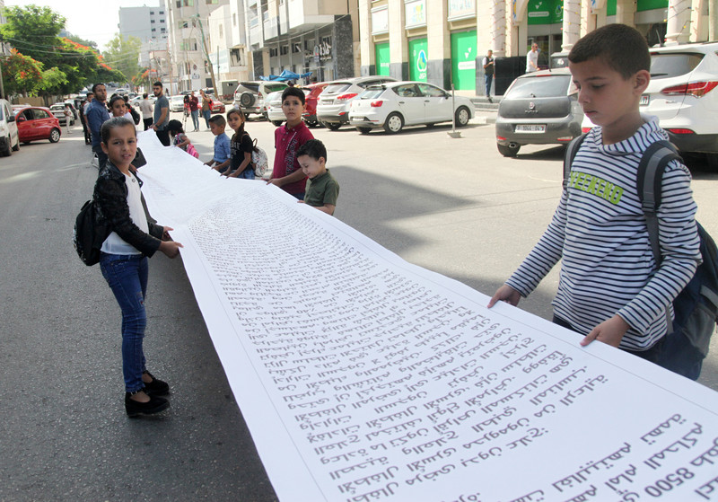 The children of Palestinian political prisoners deliver the longest letter to an international organization in front of the Gaza City office of the International Committee of the Red Cross on 28 June.  (Youssef Abu Watfa/ APA images)