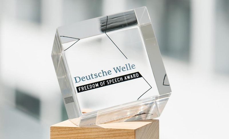 A glass and wood object with words Deutsche Welle Freedom of Speech Award engraved on it
