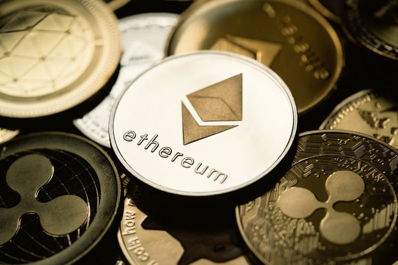 An Ethereum coin sits on top of many other digital currencies