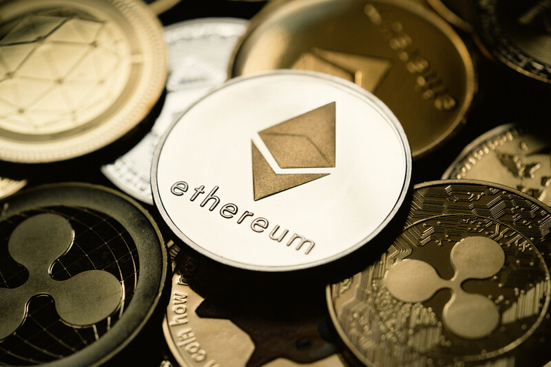 An ethereum coin sits on top of several other digital currencies