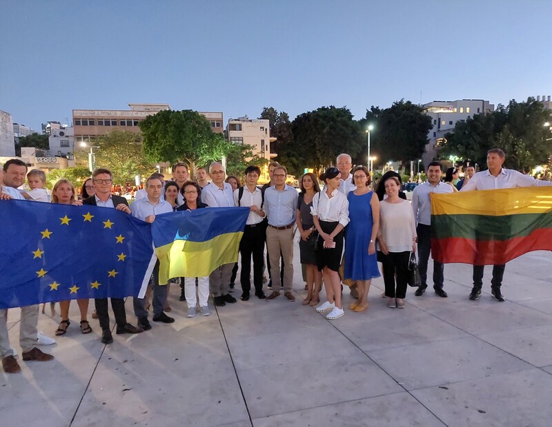 A group of people holds flags of EU and Ukraine and other countries 