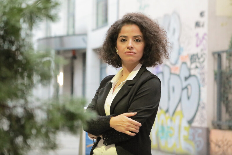 A woman stands with arms folded