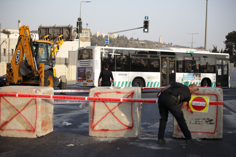 A street closed with concrete boulders and tape