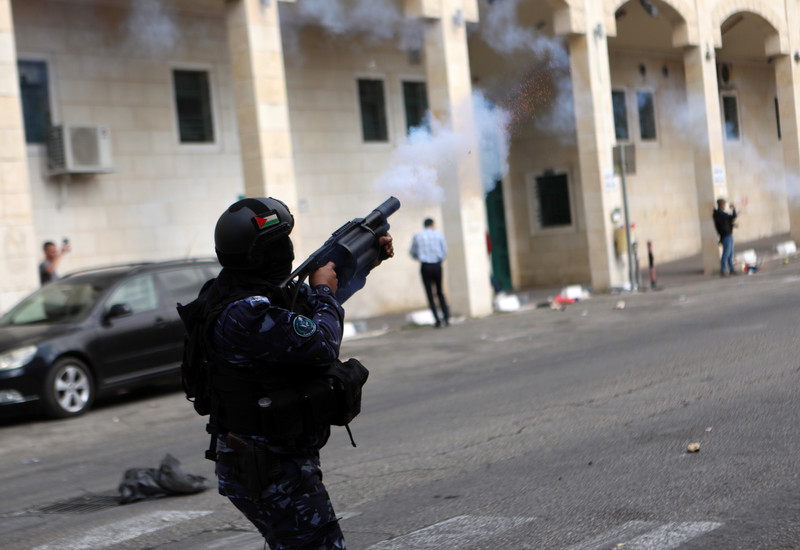 Palestinian Authority officer fires crowd control weapon while standing in street