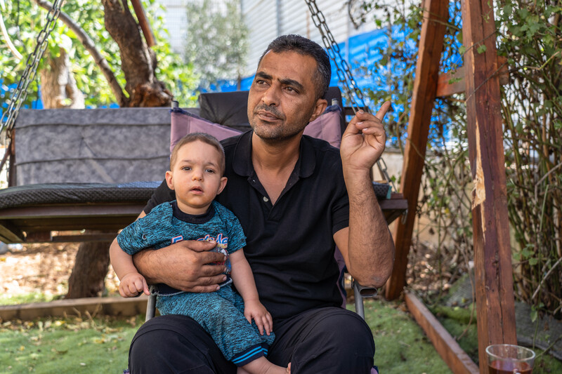 A man sits with a child on his lap