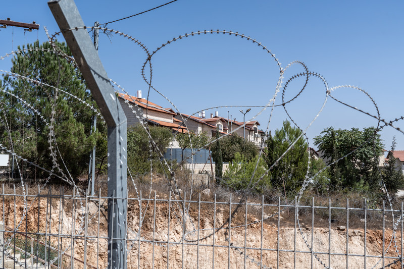A building can be seen behind barbed wire
