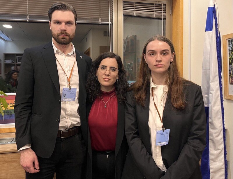 Three people in suits pose for a photo