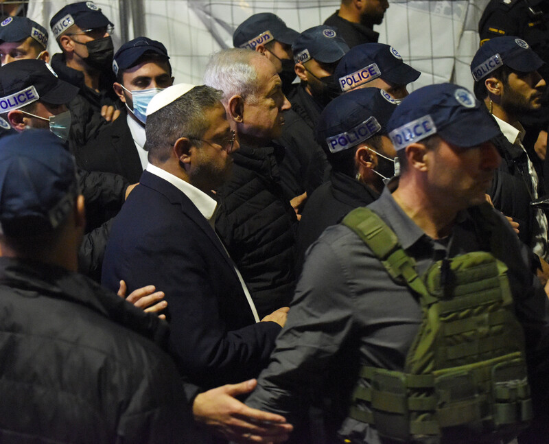 Two politicians walk alongside Israeli police officers