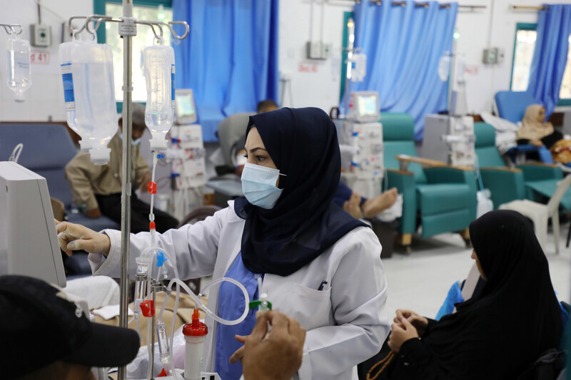 A doctor checks a screen in a hospital ward