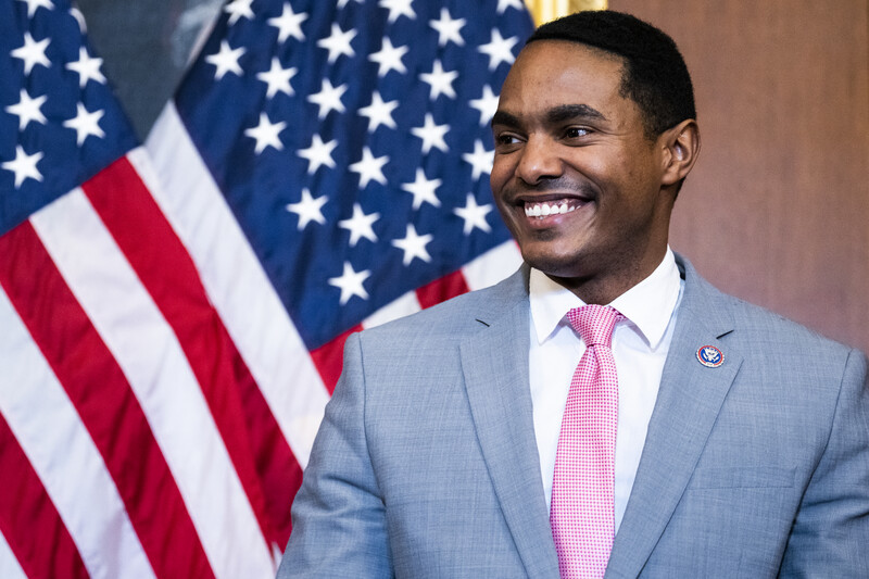 Congressman Ritchie Torres stands in front of an American flag