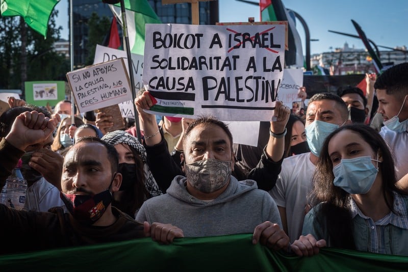 People hold signs at a demonstration calling for boycott of Israel