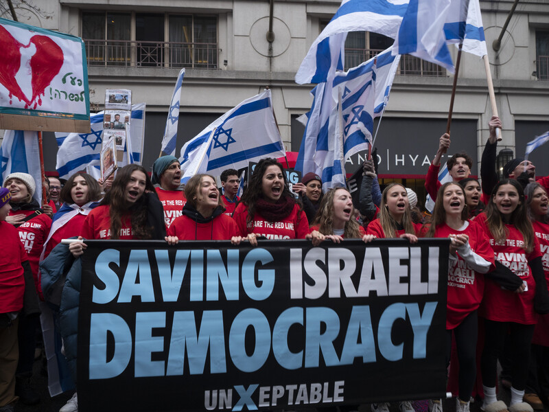 Protesters hold Israeli flags and other signs