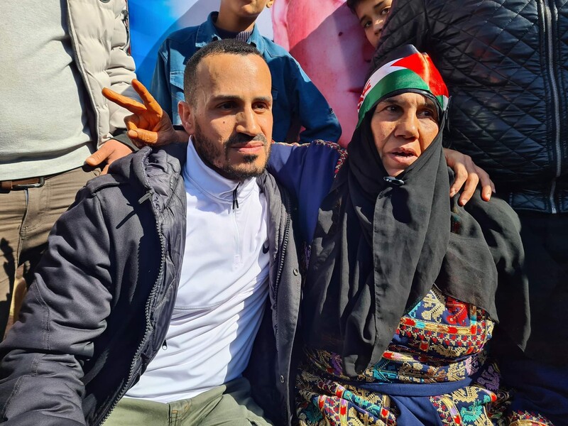 A man sits smiling next to a woman, who flashes a v-sign