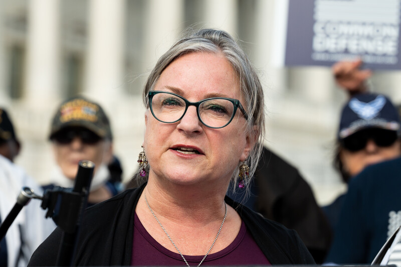 Congresswoman Susan Wild speaks at a press conference with veterans behind her