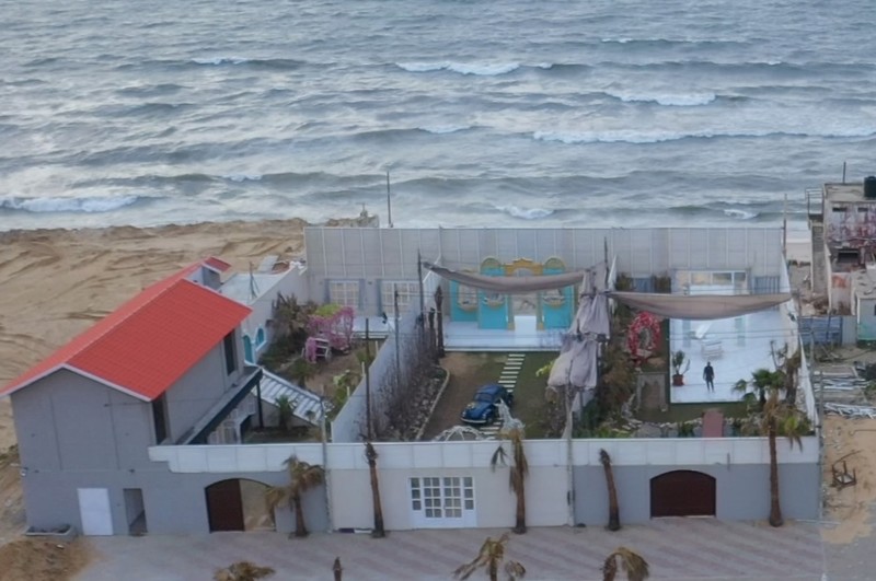 A photography studio pictured from above with a view over the sea