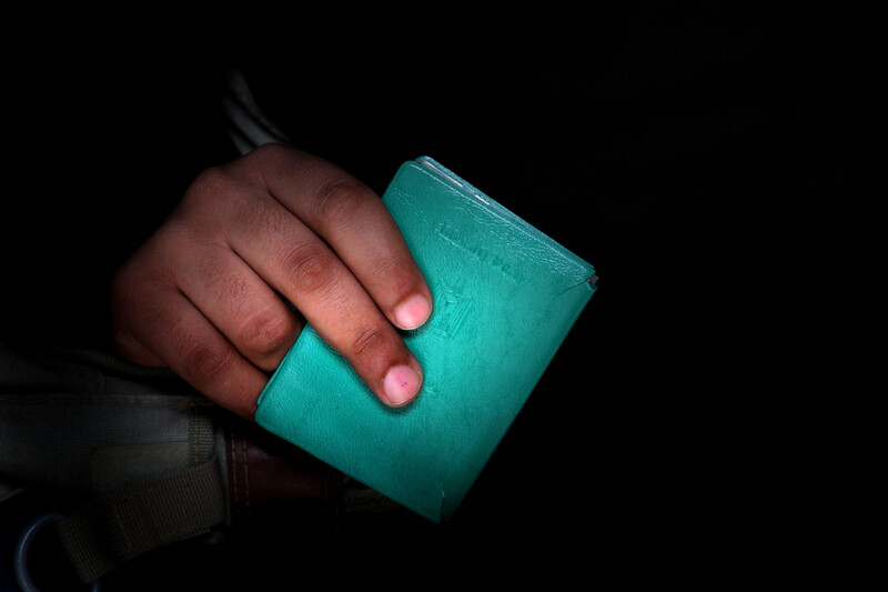 An up-close image of a hand holding a green Palestinian ID document