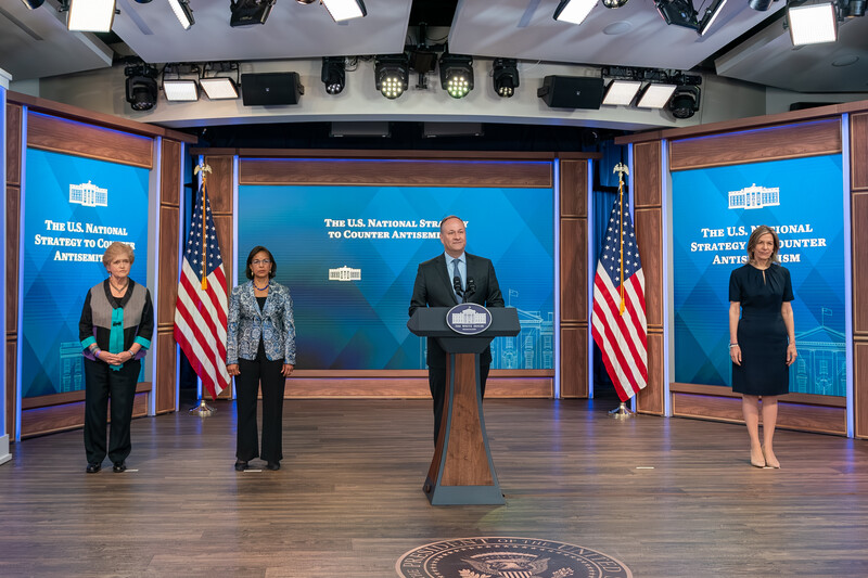 Man stands at podium flanked by other officials