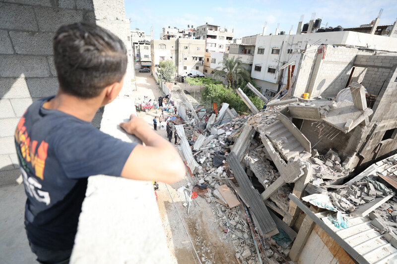 A child looks out over a destroyed house