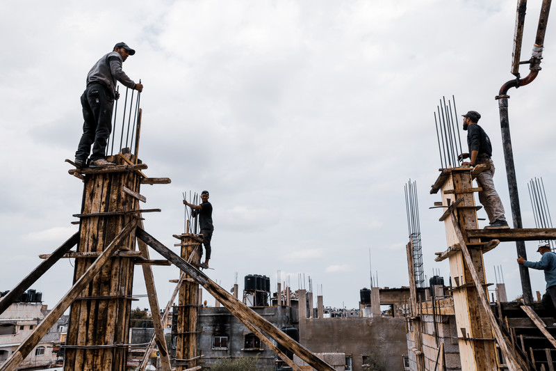 Men stand atop steel-reinforced concrete pillars