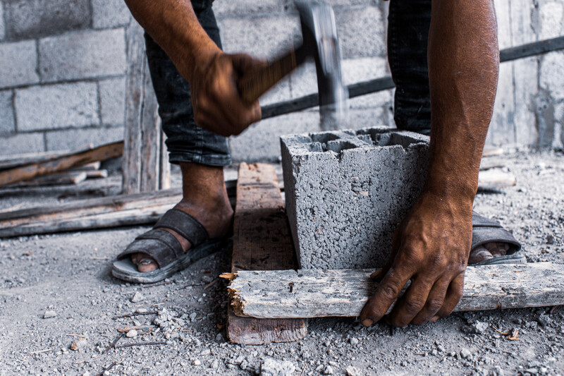 A man hammers down a nail