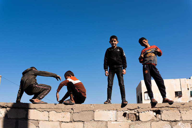 Children pose on a wall
