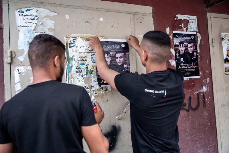 Two youths put up posters