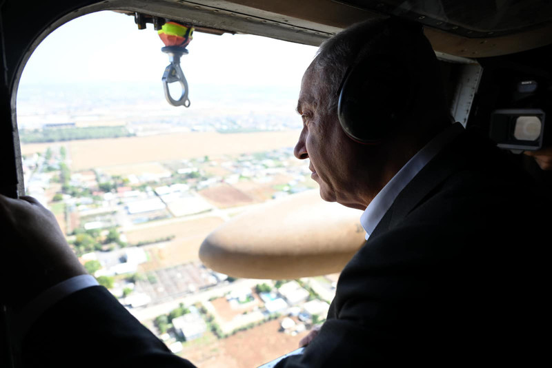 Benjamin Netanyahu, seen in profile from the chest up, looks out of a window